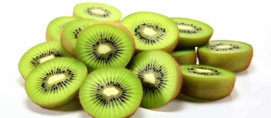 A pile of sliced Hardy kiwi fruit, a green ingredient perfect for desserts and culinary dishes, set on a white background. Enjoy this natural food in your favorite recipes