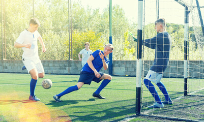 Young football players fighting for ball in goalmouth zone