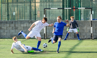 Obraz premium Youth football player kicking ball in direction of goal