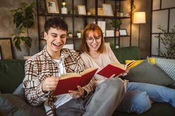 man and woman caucasian adult couple read books at home on sofa bed