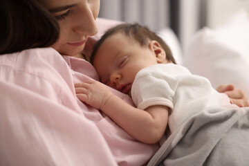 Obraz na płótnie Canvas Mother with her sleeping newborn baby in bed, closeup