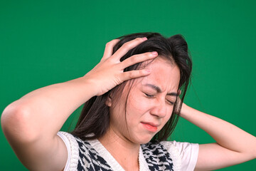 Hands of young woman on head suffering from headache desperate and stressed.