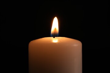 Burning candle in darkness, closeup. Memory day