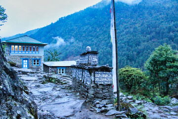 Buddhist Mantra - Om Mani Padme Hum is painted on a prayer wall and chortens dot the trail to the...
