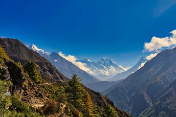 Photo sur Plexiglas Lhotse Everest and Lhotse rise like distant dreams over the landscape against a bright blue sky in this heavenly vision from Namche Bazaar