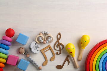 Baby song concept. Wooden notes, kids maracas and toys on table, flat lay. Space for text