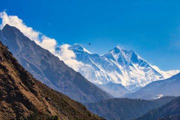 Crédence de cuisine en verre imprimé Lhotse A helicopter heads to the Everest base camp and can be seen against the towering Everest and Lhotse walls from Namche Bazaar on a brilliant summer day