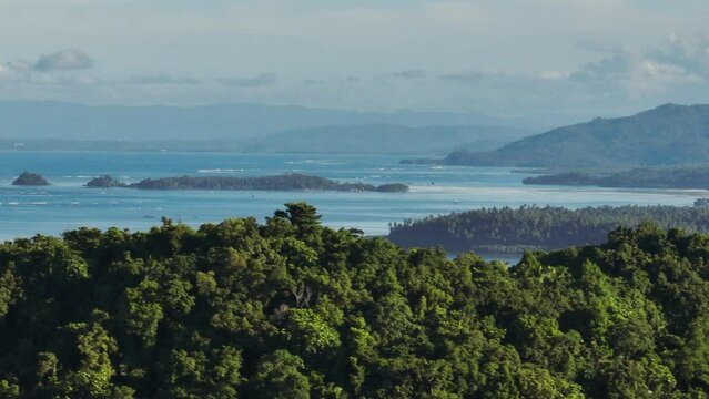 Tropical Islands with greenery trees and ocean waves. Mindanao, Philippines. Zoom view.