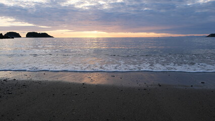 海岸から見る、太陽が海に沈む景色。