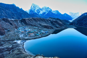 The Sheet glass like calm surface of the Gokyo lake along with the village of Gokyo and the...
