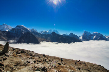 Mount Everest rises above all else in the far horizon even as clouds rise from the Ngozumpa glacier...