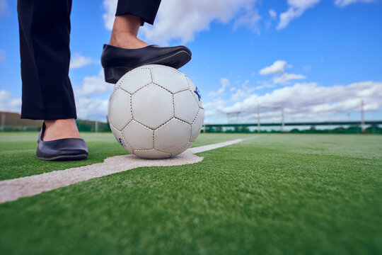 サッカーボールを足で押さえるOLの足元