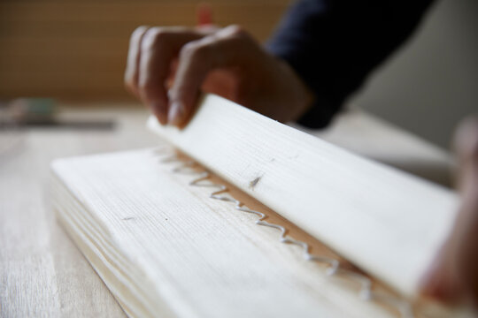 ボンドをつけた角材でDIYをする男性