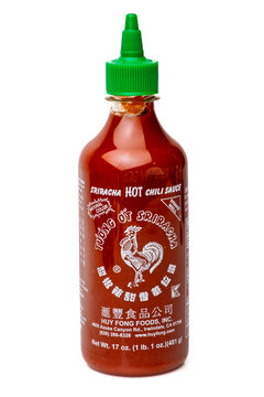 Plastic bottle of Huy Fong Food Sriracha hot chili sauce on white background