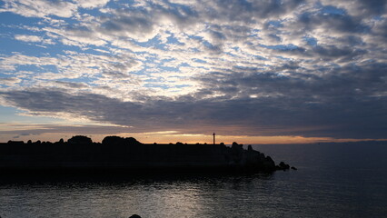 Fototapeta premium 海岸から見る、太陽が海に沈む景色。