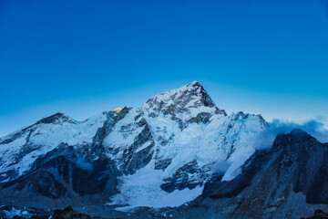 Tranquil evening photo of Nuptse 7861 meters, after sunset against an azure blue evening sky near...