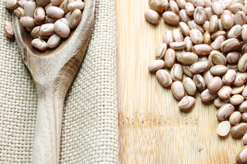 Carioca brazilian grains. Beans in a wooden spoon wooden board and jute fabric. - Powered by Adobe