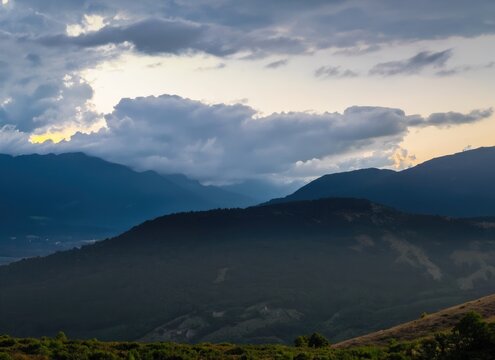 The landscape of mountains under rainy clouds at dusk
