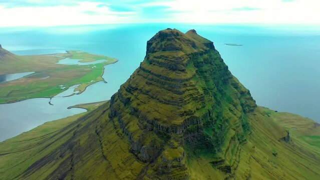 4K drone, aerial, cinematic shots of Mt. Kirkjufell mountain with the North Atlantic Ocean in the background. This mountain is the most photographed in Iceland.