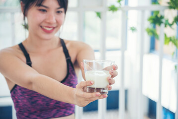 Asian women smile laugh look at camera health care home fitness lifestyle. Beautiful female drinking fresh milk low-fat dairy free lactose. Women hands holding white glass of milk pouring from bottle