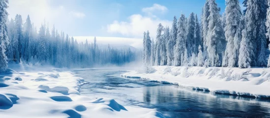 Fotobehang A river flows through a snowy forest with trees covered in snow under a cloudfilled sky, creating a stunning natural landscape in the freezing winter © 2rogan