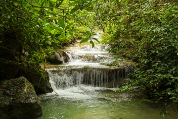 Fototapeta na wymiar Jungle landscape with flowing turquoise water of Erawan cascade waterfall