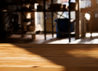 Wooden table with blurred dark shadows and natural sun light workshop interior