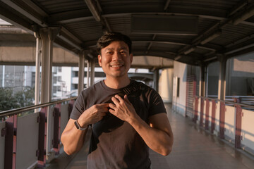 Close up of happy Asian man on the sky-train platform in Bangkok.