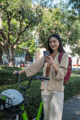 Beautiful woman taking a bike stroll in the park, business woman holding smartphone using bike rental,  business woman holding smartphone using bike rental digital phone