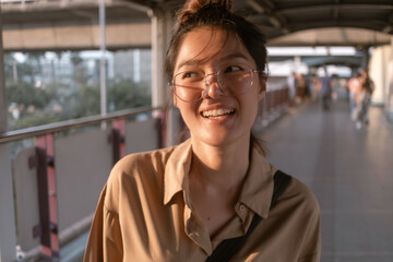 Ordinary happy asian salary woman walking on city bridge urban scene.