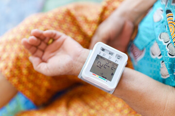 Measure blood pressure on the wrist of an elderly person.