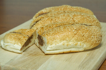 Chocolate bread bun on a wooden board.