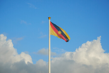 Tallest flagpole in South East Asia fly Sarawak flag with a blue sky and cloud.