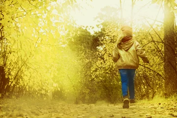 Rolgordijnen Little girl walking alone. Autumn park. Beautiful in nature. Cinematic effect toned © ElenaEmiliya