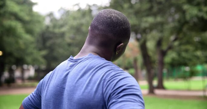 Fitness, neck stretching and black man in park for outdoor morning workout in garden from back. Health, wellness and trees with athlete in nature for warm up, exercise and training challenge for body