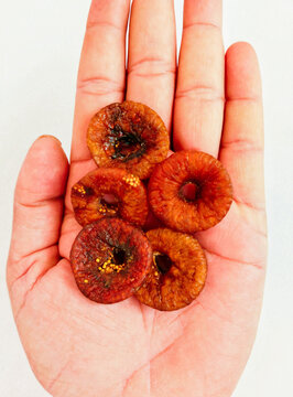 Dried figs on hand palm dry fruit food with crunchy seeds afghani brown fig sukha anjeer closeup view image picture stock photo.