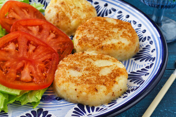 メキシコの四旬節（クアレスマ）の料理　トルティータ・デ・パパ　青背景
Cuaresma Cuisine from Mexico - Tortita de papa on blue background
