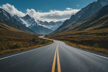 Fototapeta premium shot of a road with the magnificent mountains under the blue sky captured