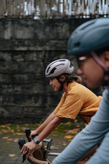 A young couple riding their bikes in the city.