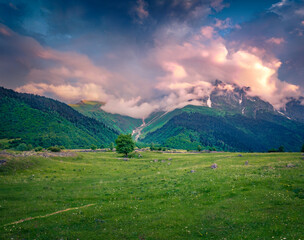Naklejka premium Dramatic summer sunrise in Caucasus mountains. Fantastic morning scene of mountain pppasture in Upper Svaneti, Georgia, Europe. Beauty of countryside concept background..