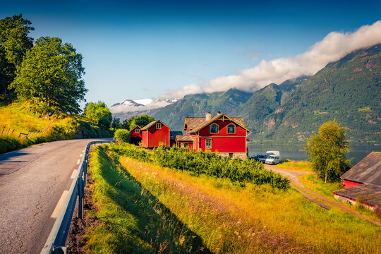 Spectacular summer scene of Lofthus village with red wooden houses, Hordaland county, Norway. Wonderful morning view of Hardangerfjord fjord. Beauty of countryside concept background.