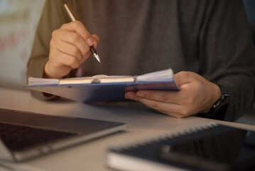 man holding clipboard with checklist employee workplace is reviewing documents.