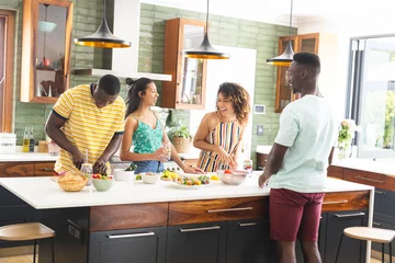 Poster Diverse group of friends preparing food together in a modern kitchen © wavebreak3