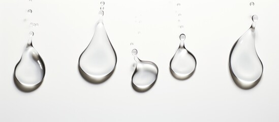 Liquid silver drops on a white surface, like body jewelry for a minimalist art piece. The metallic circle forms a delicate twig design