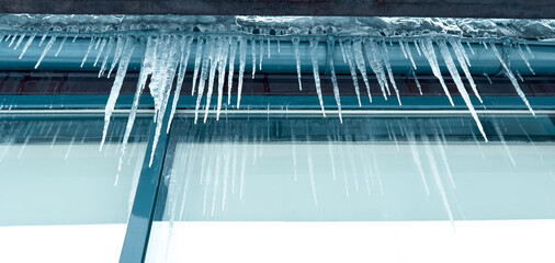 Icicles hang from a glass building - 756205054