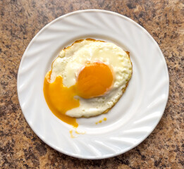 Fried egg on a white plate on the table - 756205079