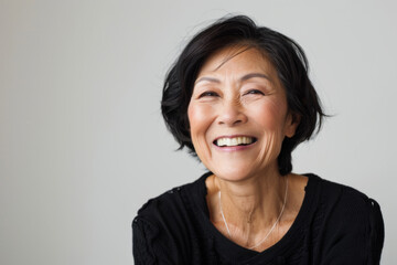 Portrait of old healthy, cheerful beautiful senior Asian woman smiling and looking at camera with white background. Happy aging society, retirement and senior healthcare concept