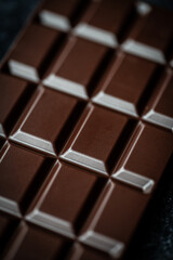 Close up macro of squares of a bar of dark chocolate from above.