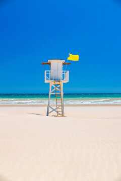 Sunny Beach Day with Lifeguard Tower and Umbrellas