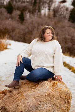 Middle aged women posing on a rock